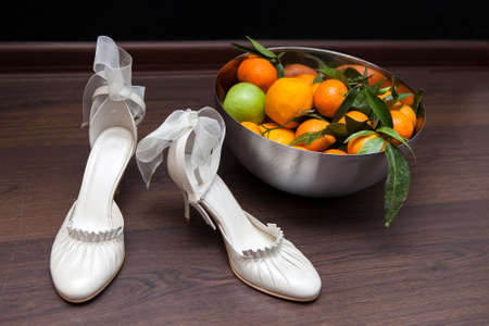 Luxury ivory wedding accessories for bride and Bright deep orange Clementine or Mandarins  in a bowlの写真素材