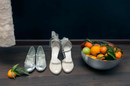 Luxury ivory wedding accessories for bride and Bright deep orange Clementine or Mandarins  in a bowlの写真素材