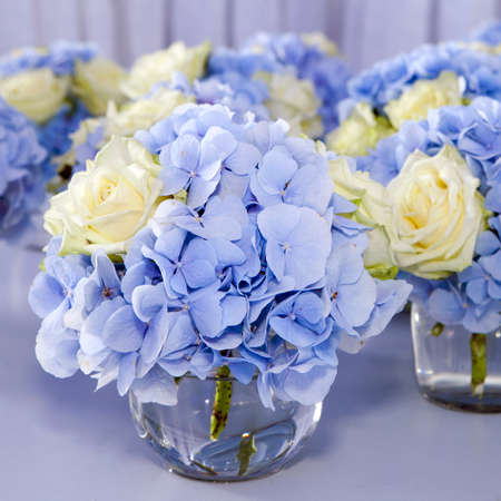 Bouquet of white and blue flower in vase of glass. Decoration of dining table.の写真素材