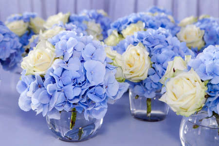 Bouquet of white and blue flower in vase of glass. Decoration of dining table.の写真素材