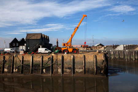 WHITSTABLE, KENT, UK - DEC 9: A very low tide strands fishing boats on the mud in the Harbour at Whitstable, Kent, Uk on Dec 9, 2013.のeditorial素材