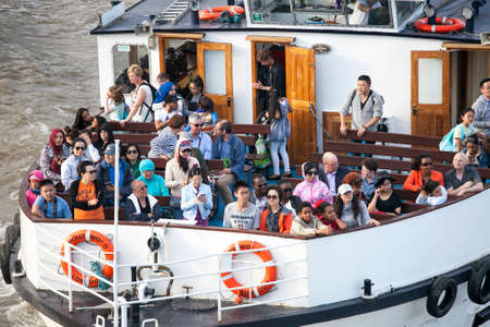 LONDON, UK - 18TH JULY 2016: A boat on the River Thames in London. Lots of people can be seen on the boat.のeditorial素材