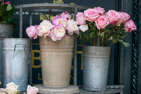 roses and peonies in aluminum buckets on the counter for saleの写真素材