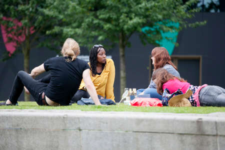 LONDON, UK - August 14, 2016: - Brits chilling up after work on grass at South Bank in Londonのeditorial素材