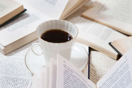 Still life details, cup of coffee on retro vintage books on a coffee table in living room, top view point. Lazy winter weekend with a books on the sofa.の写真素材