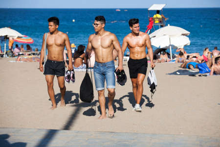 JUNE 18, 2016 - BARCELONA, SPAIN: Unidentified Well-built men in shorts are on the beach at Barcelona cityのeditorial素材