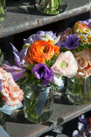 rose, chamomile, eucalyptus, anemone, freesia in a glass jar on the steps