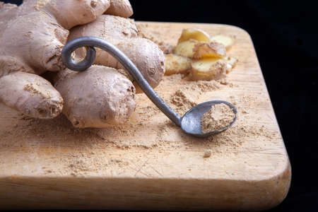 Close up of different forms of ginger against a wood worktopの写真素材