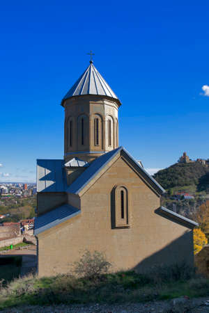 TBILISI, GEORGIA, 16 AUGUST, 2016: Narikala Fortress with the St Nikolas church and the architecture in the surrounding Old Town of Tbilisi, Republic of Georgia, Caucasus, in the early morning, at sunrise.の写真素材
