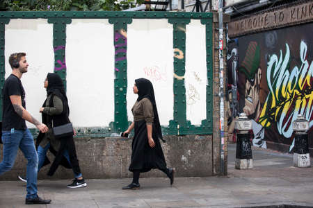 LONDON, UK - August 27, 2016: Asian people walking on the street Brick Lane, London, England