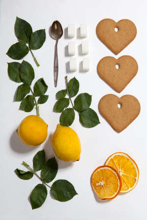Ornament of lemons, cookies and rose leaves on white background. Recipe of gingerbreadの写真素材