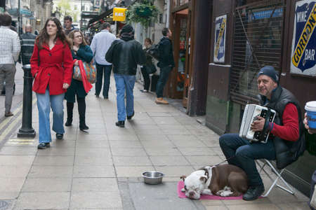 LONDON - August 27, 2016: Street musician playing the accordion, with the dog