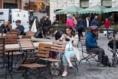 LONDON - SEPTEMBER 27, 2016: Women buried in the phone, waiting for the friend around Covent Gardenのeditorial素材