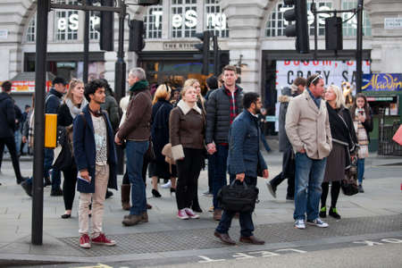 LONDON, ENGLAND - JULY 12, 2016 People of different nationalities go on the sidewalk. A motley crowd...