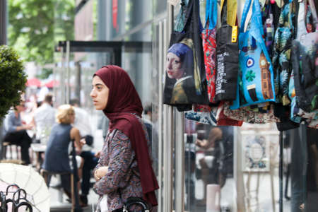 LONDON, UK - August 27, 2016: The girl wearing the hijab on the background of the bag with a picture "Girl with a Pearl Earring"のeditorial素材