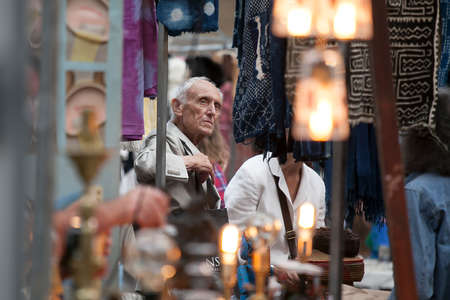 London, UK - July 1, 2016: Customers looking at antiques at a stall in Brick Lane, Whitechapel. Portrait of old manのeditorial素材