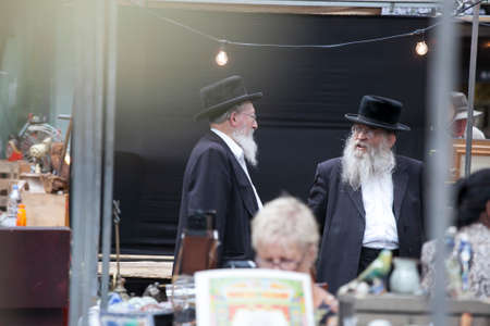 LONDON, UK - August 27, 2016: Two elderly Orthodox Jewish men with beards wearing black coats and...