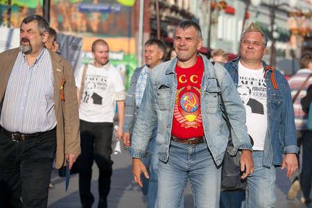 MOSCOW,RUSSIA - MAY 9,2016: May 9,Russia celebrates victory over Nazi Germany,while remembering those who died. men in T-shirts with symbols of the Soviet Union are on the streetのeditorial素材