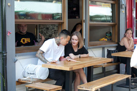 LONDON, ENGLAND - JULY 12, 2016 Life of street cafe. Man and woman sitting at a table at an outdoor...
