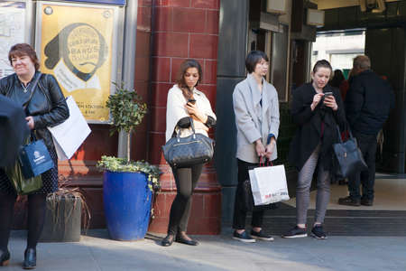 London, UK - July 17, 2016. Women are waiting for friends near Covent Garden, buried in mobile phonesのeditorial素材
