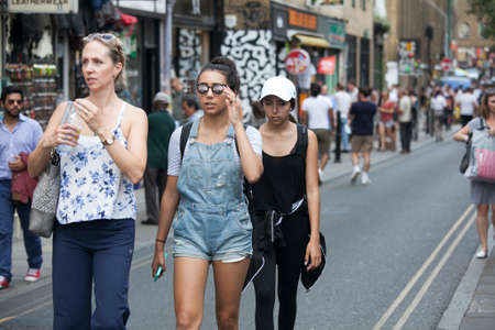 LONDON, UK - August 27, 2016: hipster gilrs dressed in cool Londoner style walking in Brick lane, a street popular among young trendy peopleのeditorial素材