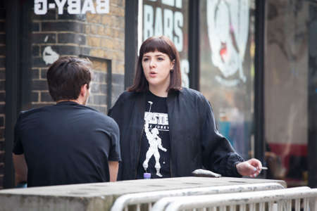 LONDON, ENGLAND - JULY 12, 2016 Hipster girl talks to her friend in local cafeのeditorial素材