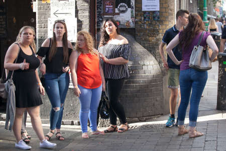 LONDON, ENGLAND - JULY 12, 2016 hipster women dressed in cool Londoner style walking in Brick lane,...