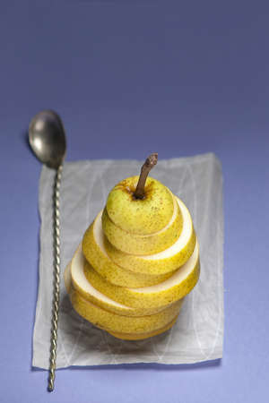 the sliced circles pear on a white napkin at blue background, sprinkled with sugar
