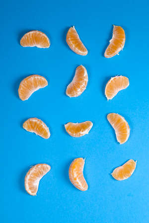 Slice sections of tangerine isolated over the blue backgroundの写真素材