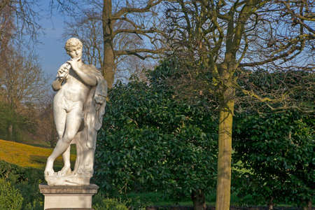 Marble Statue of the Naked God Pan Playing a Flute in the Queens Garden Behind Kew Palace at the Royal Botanical Gardens, Kewのeditorial素材