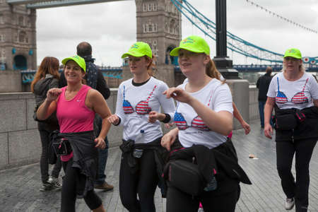 LONDON, UK - APRIL 22, 2016: PGirls wear T-shirts with printed bras running, hold rally in support of breast cancer patients at South bankのeditorial素材