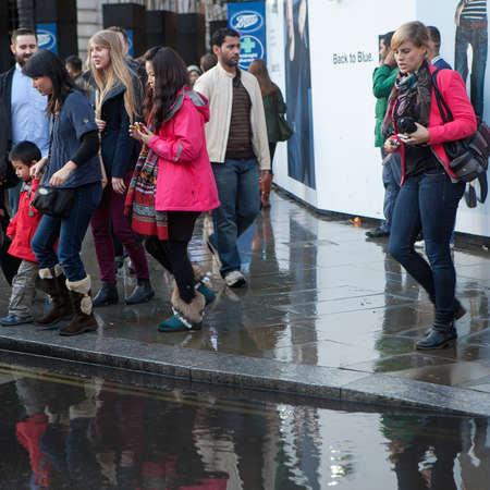 LONDON, UK - APRIL 22, 2016: People bypassed a large puddle near Piccadilly Circus, trying to cross the roadのeditorial素材