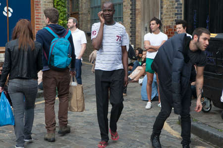 LONDON, ENGLAND - JULY 12, 2016 Sunday flower Columbia road flower market. The local going for flower, sitting on sidewalks, drink wine, eat and listen to the street musicians. Some of them dancing.のeditorial素材