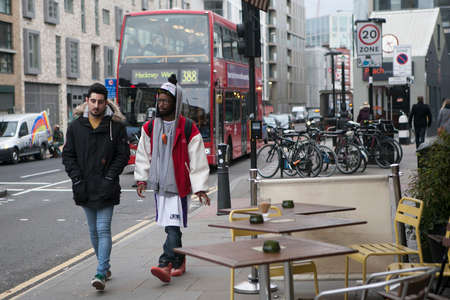 LONDON, UK - APRIL 22, 2016: Two fashionably-dressed friend go on Brick Laneのeditorial素材