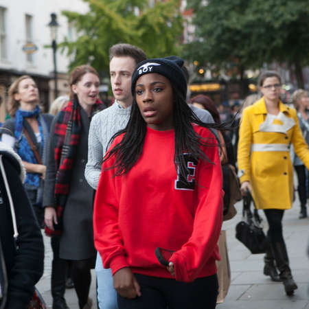 LONDON, ENGLAND - April 12, 2016 Serious woman in a red sweater makes her way through the crowd to Liverpool Streetのeditorial素材
