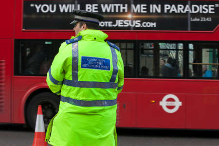 London, UK Thursday March 23, 2017   The policeman stands opposite the passing bus, on which the slogan - you will be with me in paradise. After the terrorist attack in Londonのeditorial素材