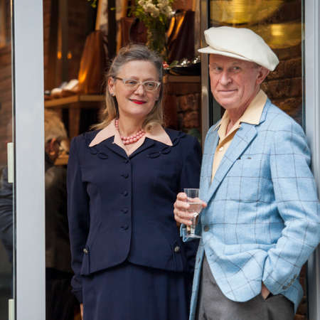 LONDON, ENGLAND - March 30, 2017 A man and a woman, aged in the style of the forties, stand in the doorway of a cafeのeditorial素材