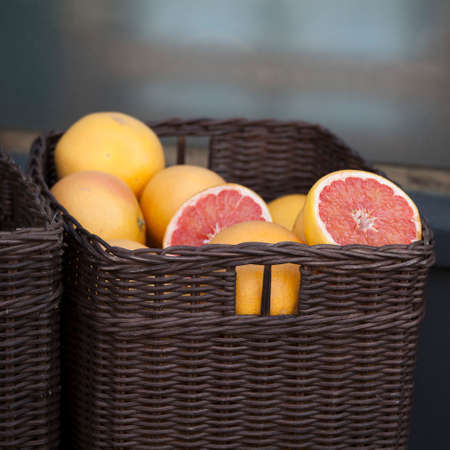 Wicker basket with grapefruits on the table near the store. Selective focusの写真素材