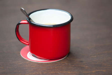 Red enameled mug on a wooden tableの写真素材