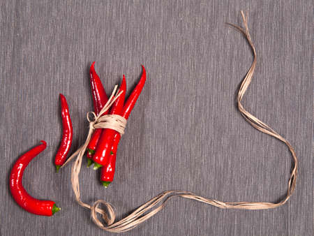 Postcards for recipes. Red chile pepper, tied with twine, on a gray napkin. Copy spaceの写真素材