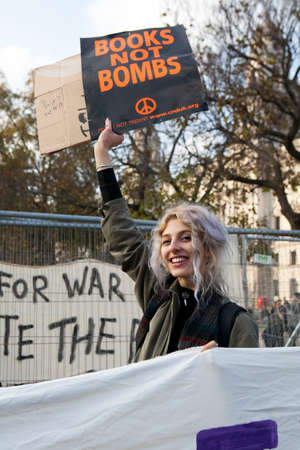 London, UK. 19th Nov, 2016. Students protest against fees and cuts and debt in central London. Girls holds placard "Books not bombsのeditorial素材