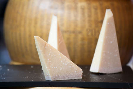 Parmesan is on the table for sale on the market. Parmigiano-Reggiano is made from unpasteurized cow's milk.の写真素材