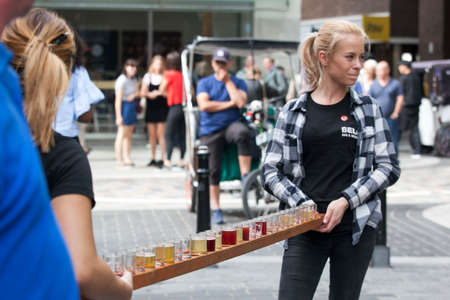 LONDON, ENGLAND - August 11 2017 Girls promouters keep glasses of beer on a long tray. Girls are advertising a beer restaurant near Covent Garden.のeditorial素材