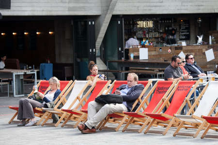 LONDON, ENGLAND - August 11 2017 People read books sitting in loungers near the National Theaterのeditorial素材