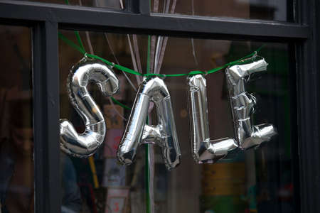 inflated silver "Sale" sign in the store windowの写真素材