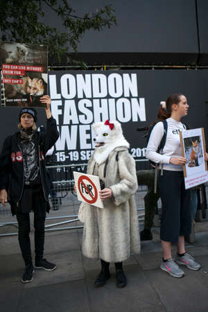 LONDON, ENGLAND - September 15, 2017 Anti fur protest during London Fashion Week. outside Eudon Choi. woman in a fur coat and wolf mask is holding poster - no furのeditorial素材