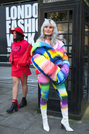 LONDON, ENGLAND - September 15, 2017 Two friends in colorful clothes posing near a black phone booth during the London Fashion Week. outside Eudon Choiのeditorial素材