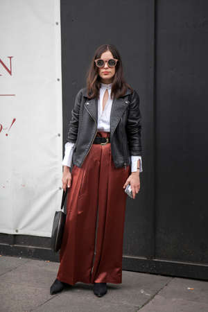 LONDON, ENGLAND - September 15, 2017 Beautiful and stylish A woman in a black leather jacket and claret trousers posing during the London Fashion Week. outside Eudon Choiのeditorial素材