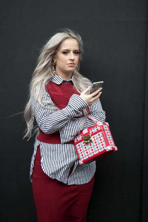 LONDON, ENGLAND - September 15, 2017 Beautiful and stylish woman in red nice dress posing during the London Fashion Week. outside Eudon Choiのeditorial素材