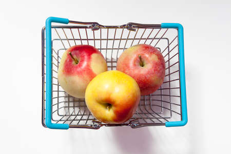 the Shopping basket with apple isolated on white backgroundの写真素材